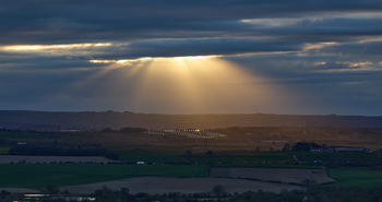 Gods rays on a cloudy spring evening over a solar farm_2.jpg